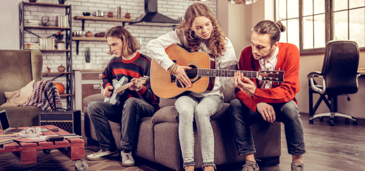 Family playing music in a modern living room with hardwood flooring